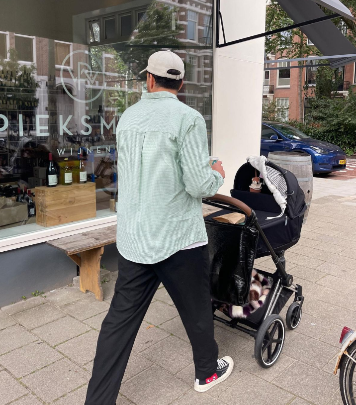 Man met een kinderwagen op straat.